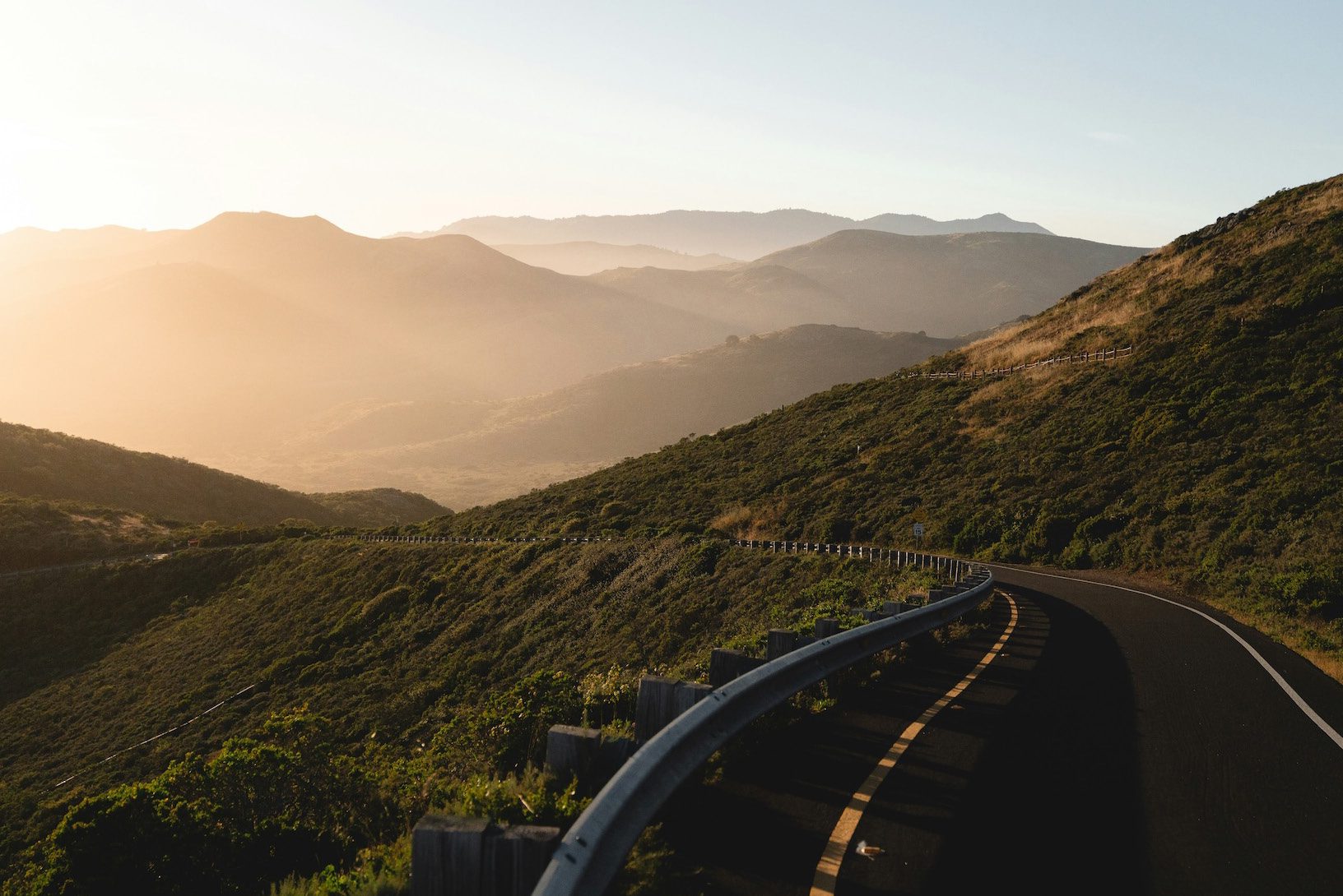 A road curving through the KwaZulu-Natal mountains at sunrise